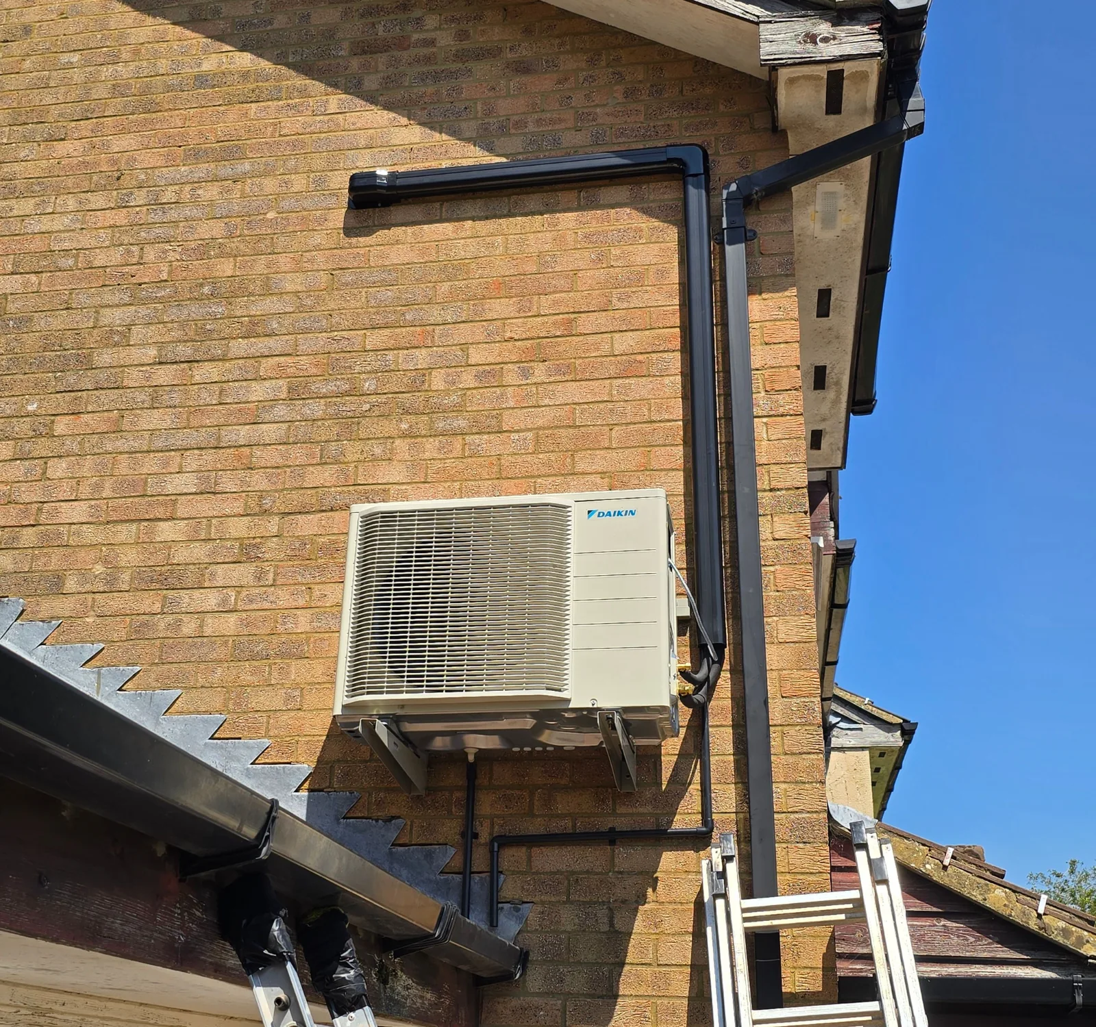 Outdoor air conditioning unit fitted to a brick wall