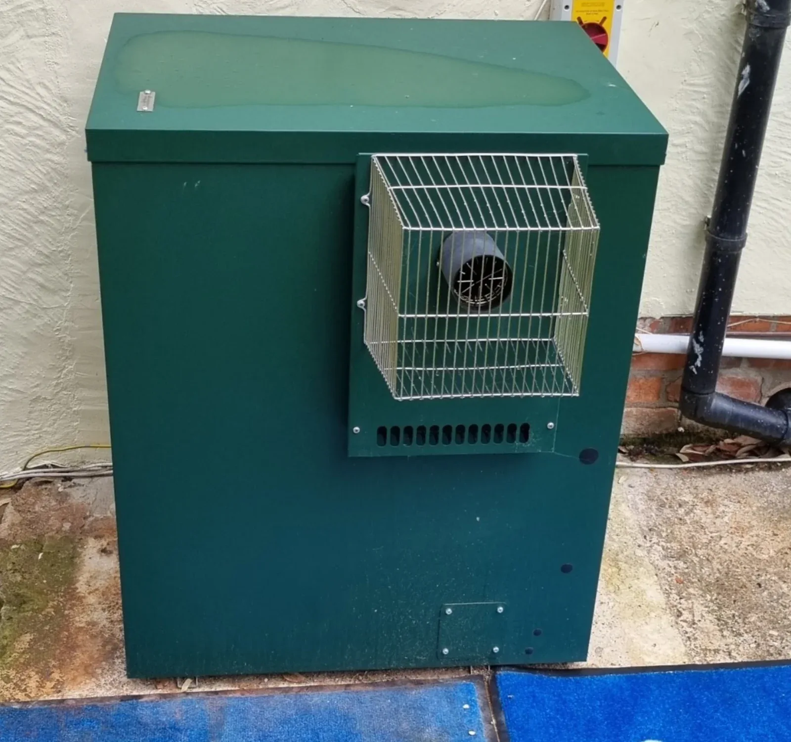 Close-up of an external oil boiler and flue terminal